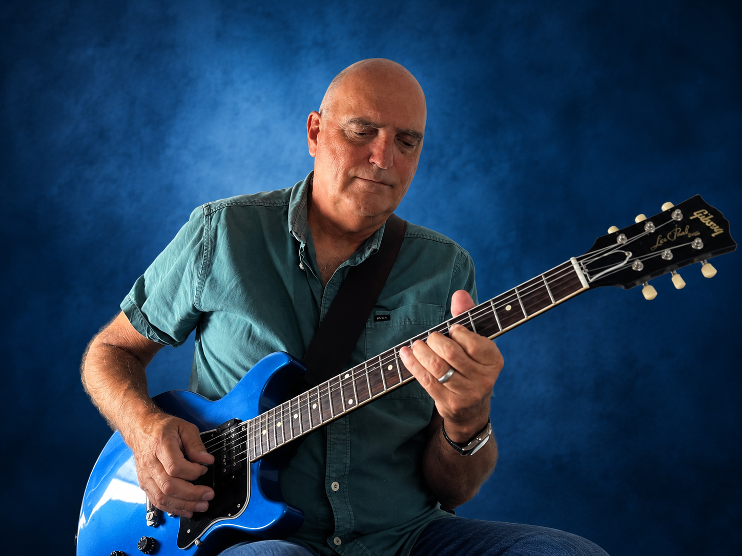 Ryan Hold playing his blue Gibson guitar in a relaxed setting